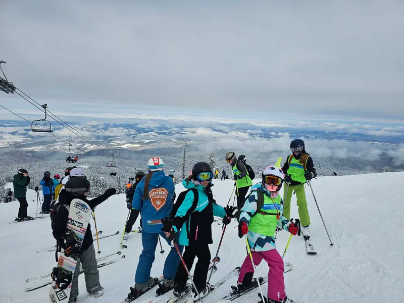 Ομάδα σκιέρ και snowboarders στην κορυφή της πλαγιάς